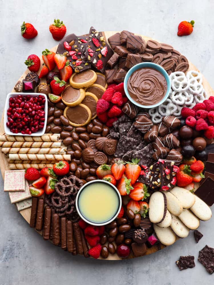Top view of chocolate charcuterie board. Berries and chocolate pieces are scattered next to the board.