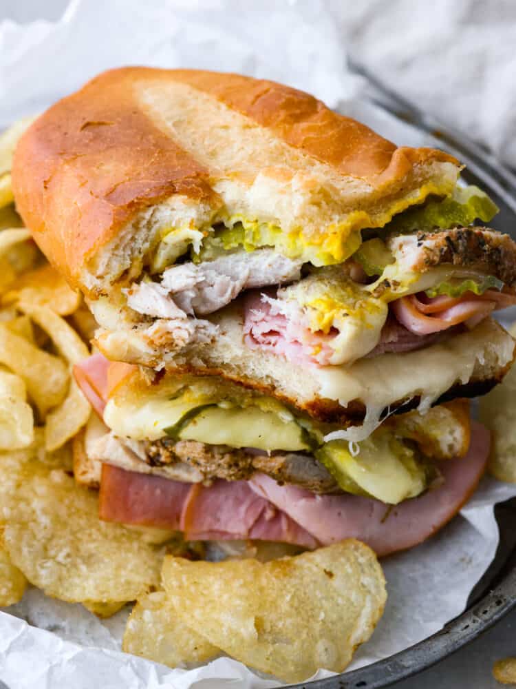 A Cuban sandwich on a plate with a bite out of it. 
