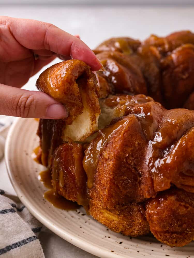 A piece of monkey bread being pulled apart.
