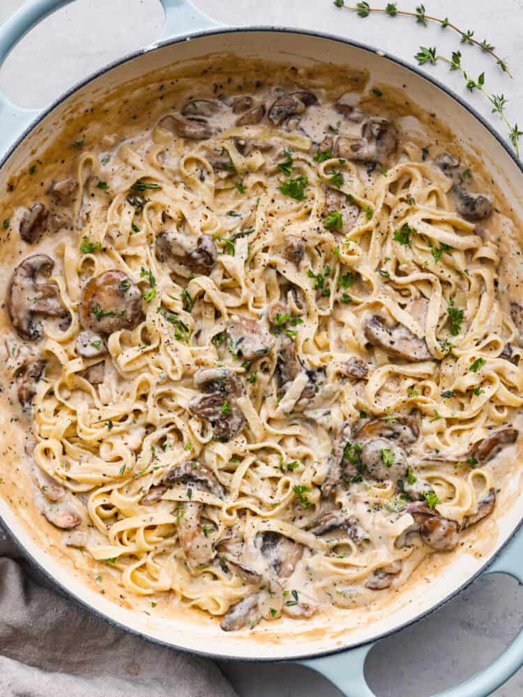 Top-down view of mushroom pasta in a blue skillet.