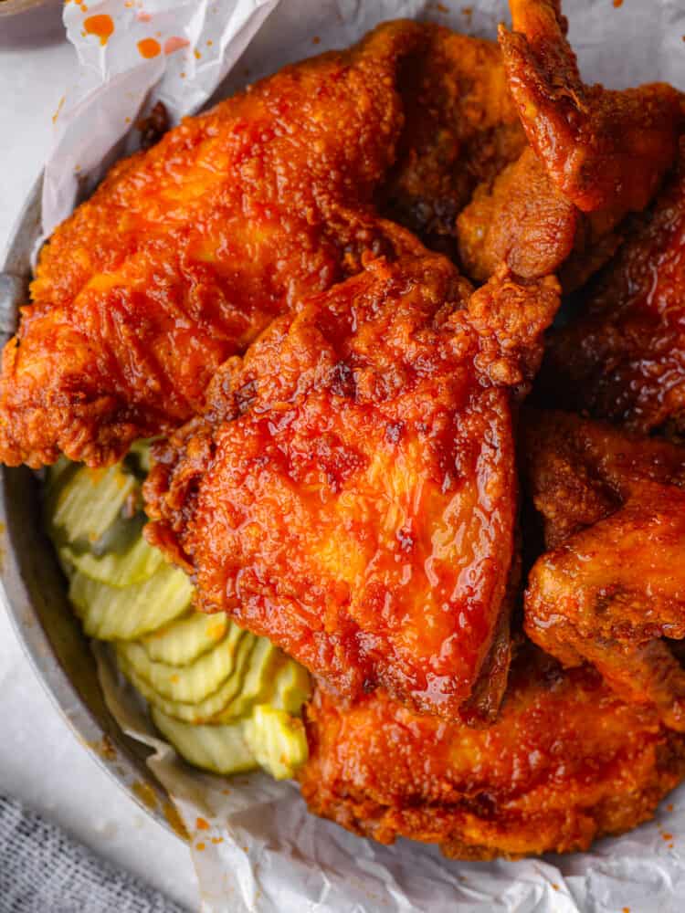 Nashville hot chicken served with sliced pickles.