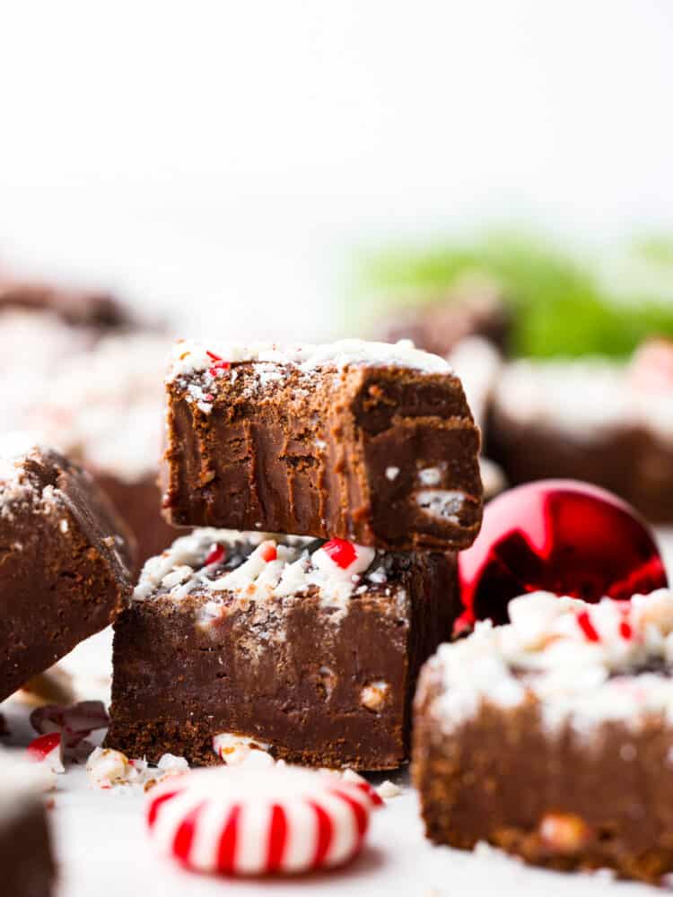 Peppermint fudge stacked on top of each other, one with a bite taken out of it.