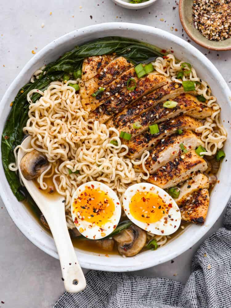 Top-down view of homemade ramen topped with chicken, bokchoy, and a soft boiled egg.