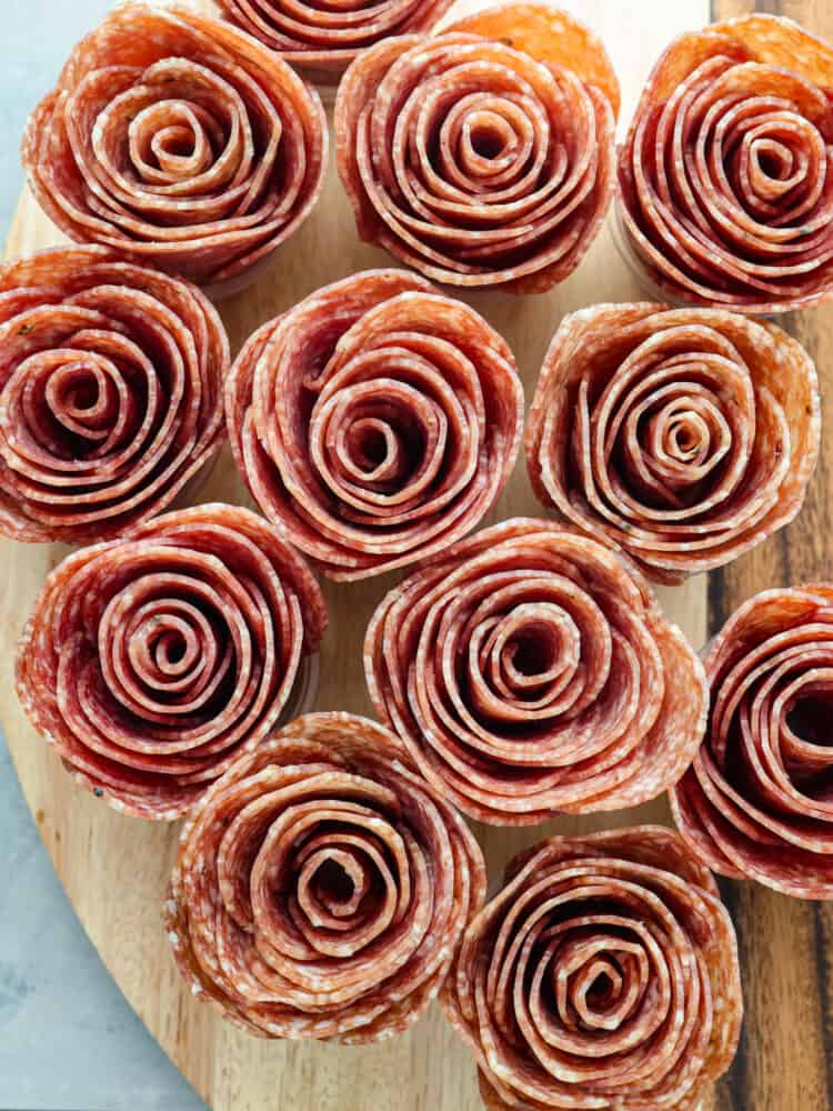 A close up of the meat flowers on a wooden board.