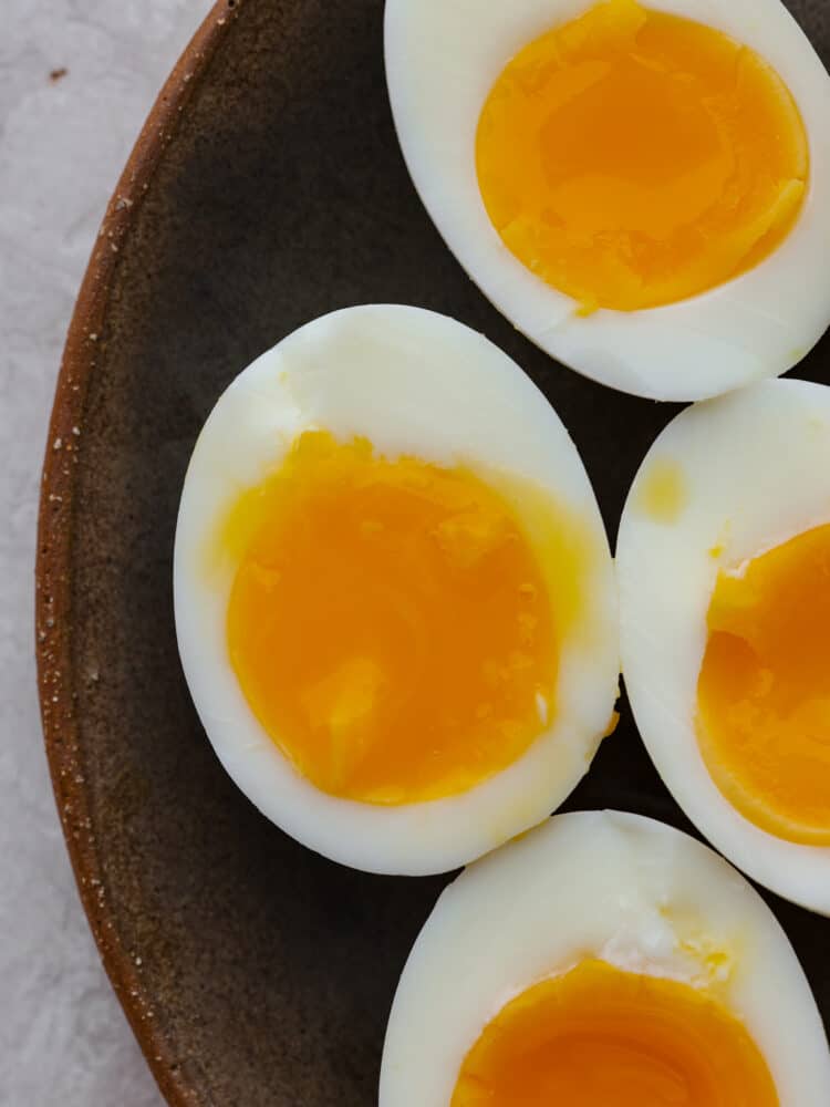 A close up of soft boiled eggs cut open to see the yolks.