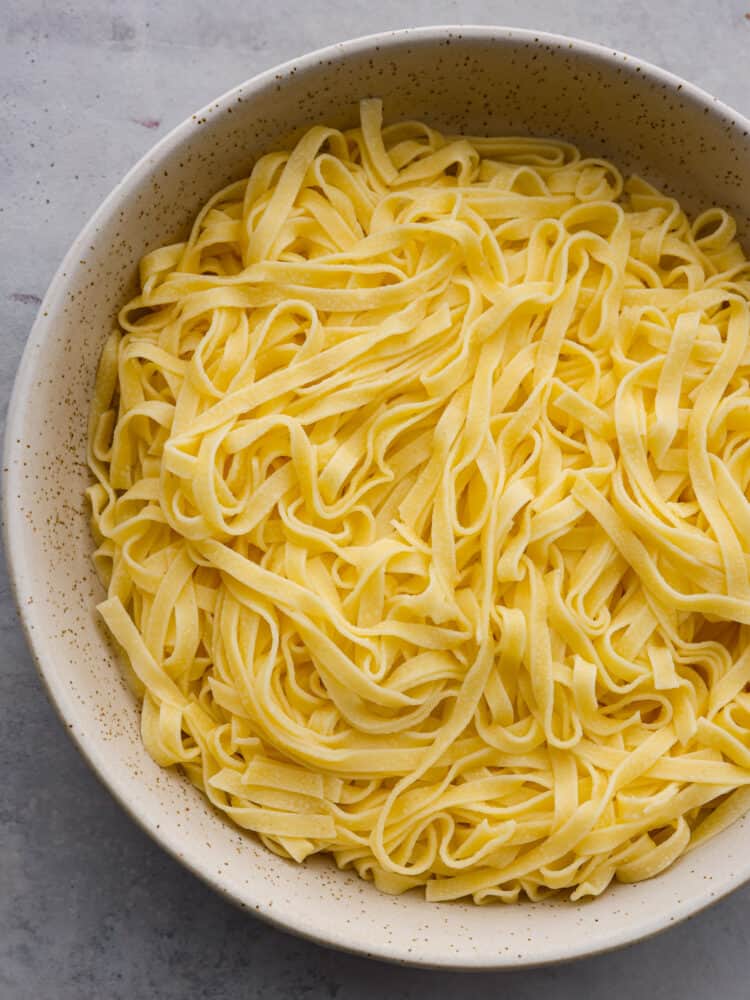 Top-down view of cooked tagliatelle in a spotted bowl.