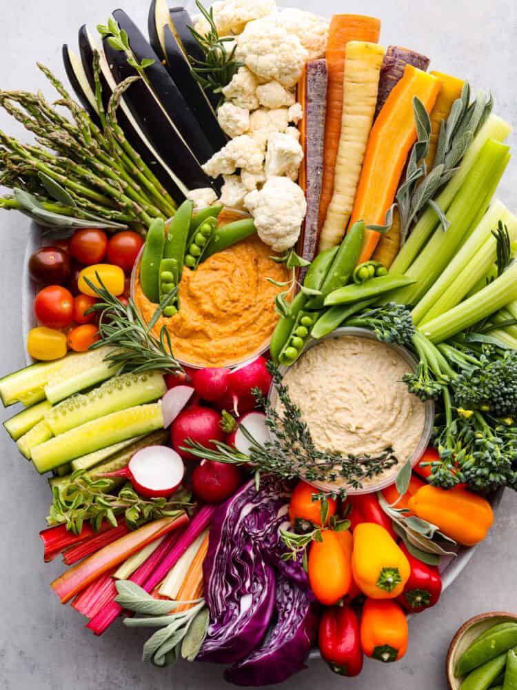 A crudités tray full of vegetables and hummus.