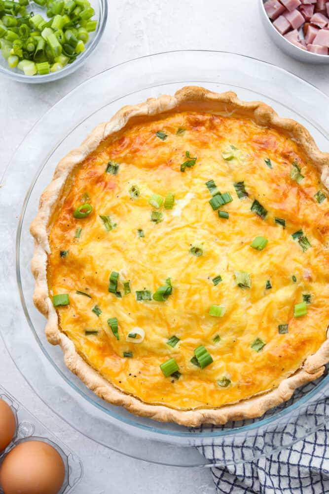 The top view of a ham and cheese quiche in the pan. 