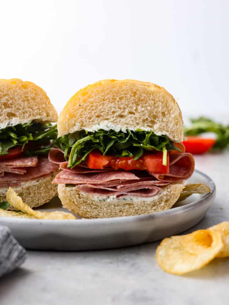 Ein Bild des Sandwiches auf einem Teller mit Kartoffelchips daneben.