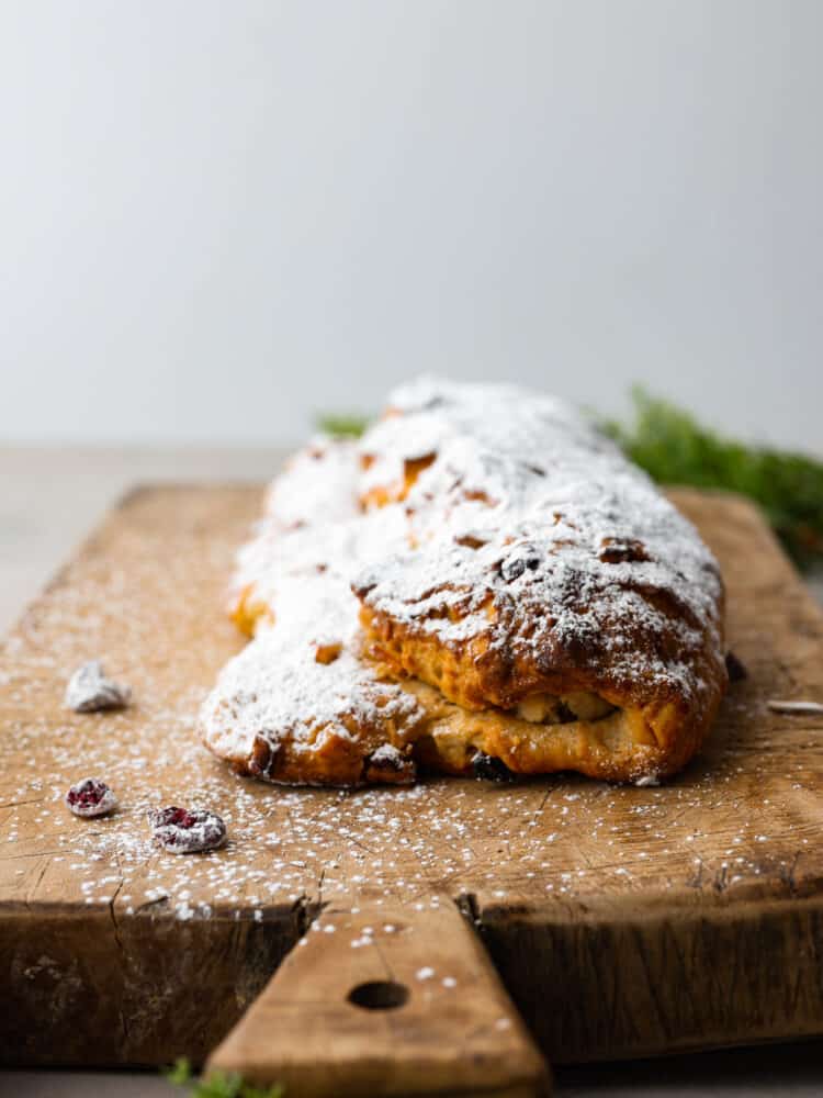 A loaf of stollen on a wooden board.