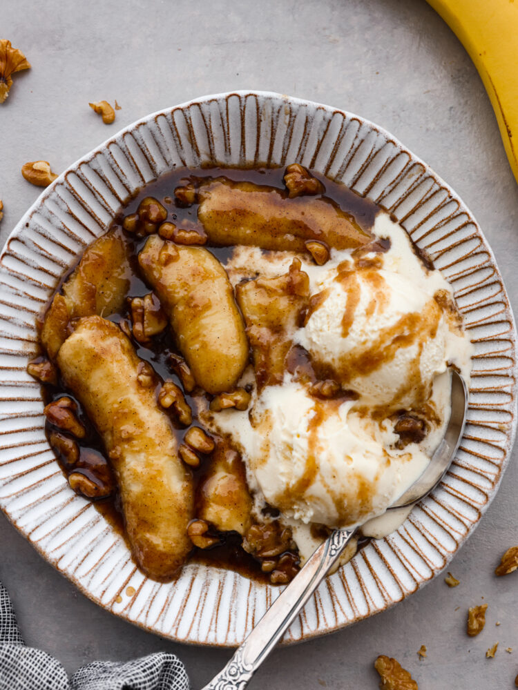 Bananas foster served with ice cream in a white stoneware bowl.