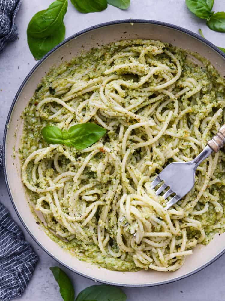 Miska makaronu z kremowym pesto na wierzchu.