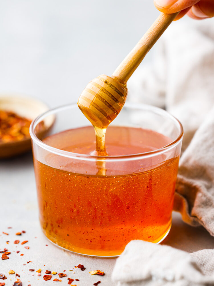 Hjältebild av varm honung serverad i en glaskopp.