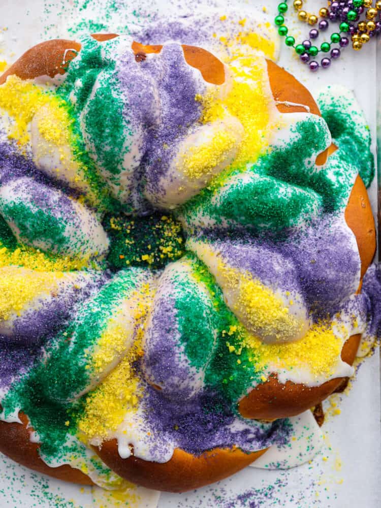 Top-down view of king cake, covered in purple, yellow, and green sanding sugar.