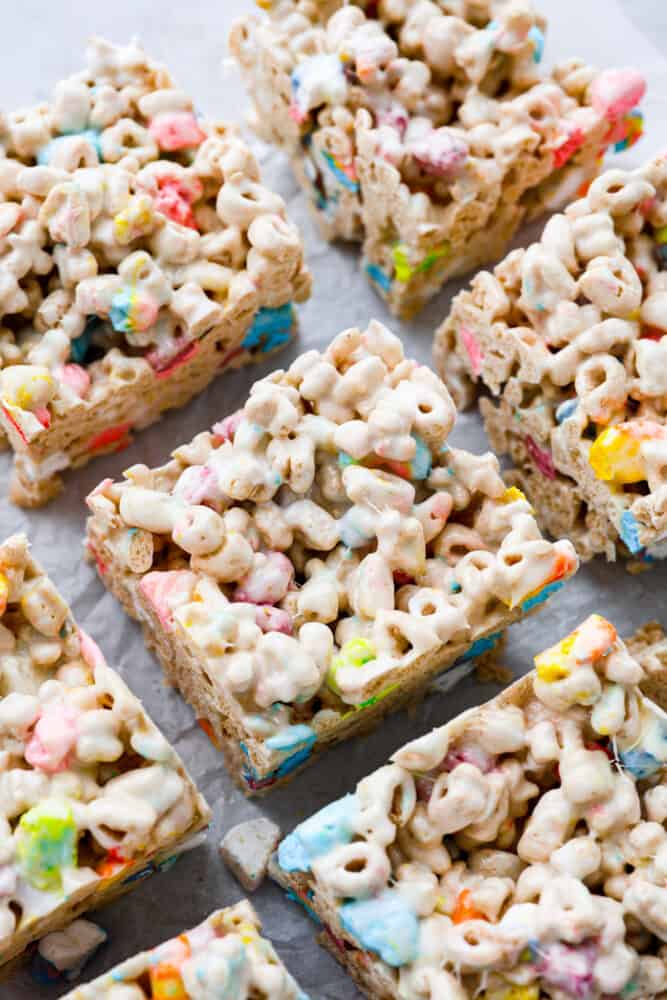 Lucky charms treats cut into bars on top of parchment paper.