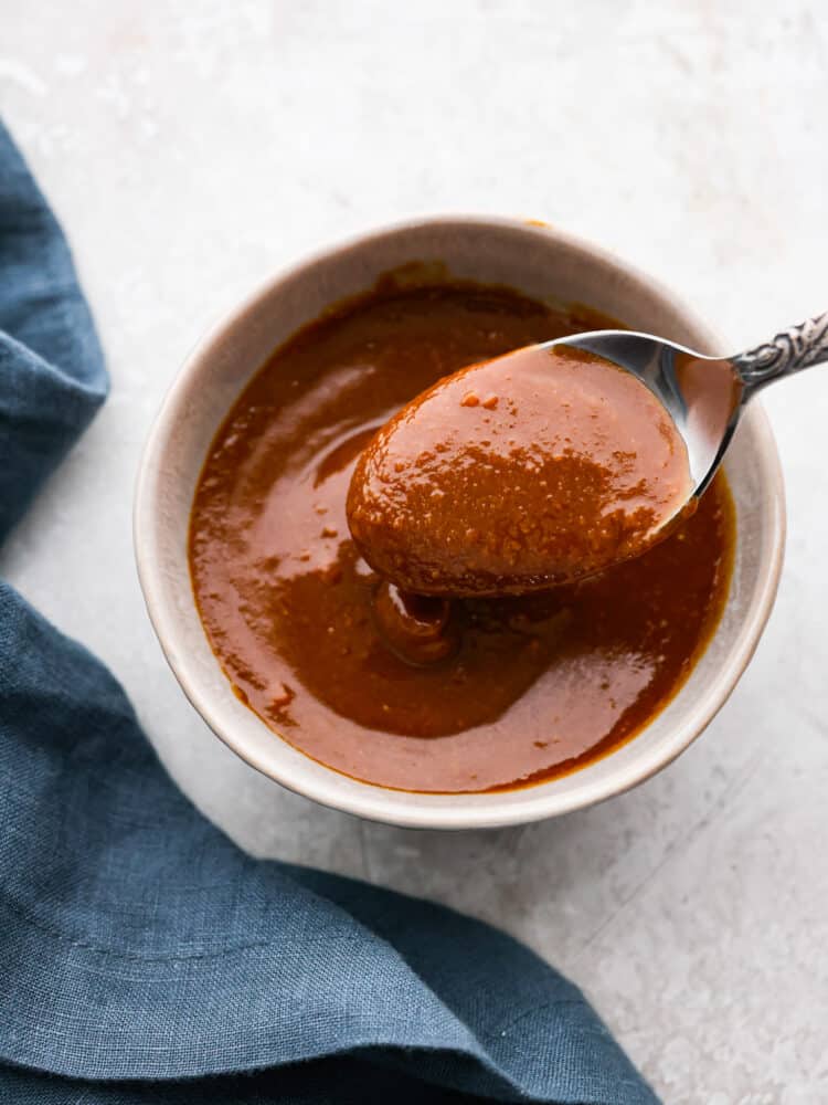 Miso glaze in a bowl with a spoon taking some out of it.