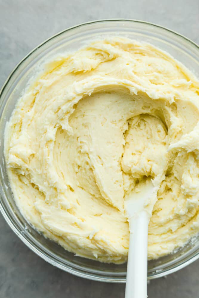 Top-down view of buttercream frosting in a glass bowl.