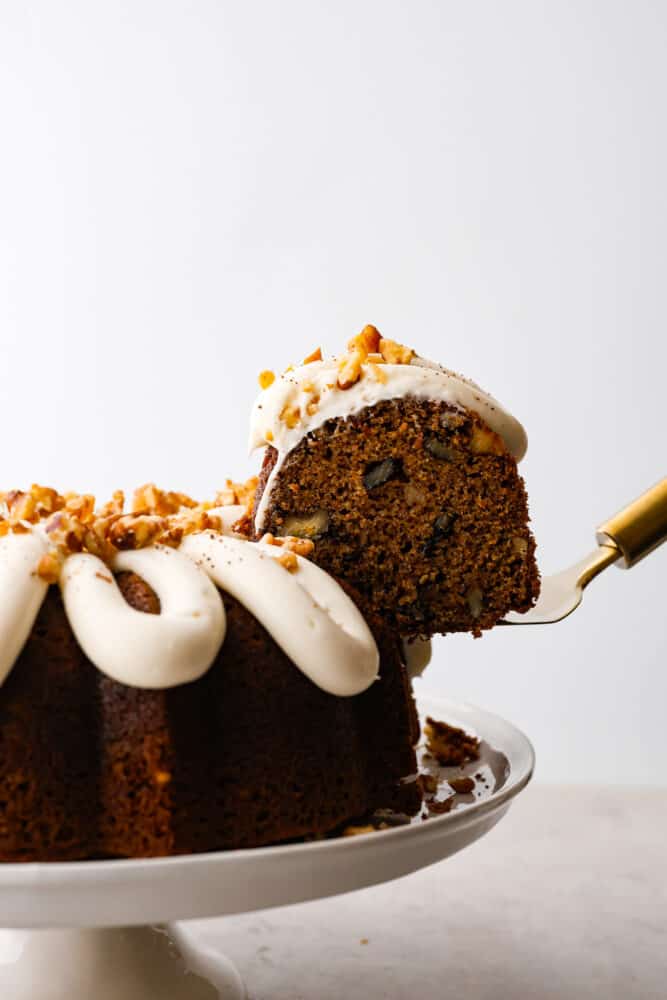 A slice of carrot bundt cake being lifted up by a spatula.