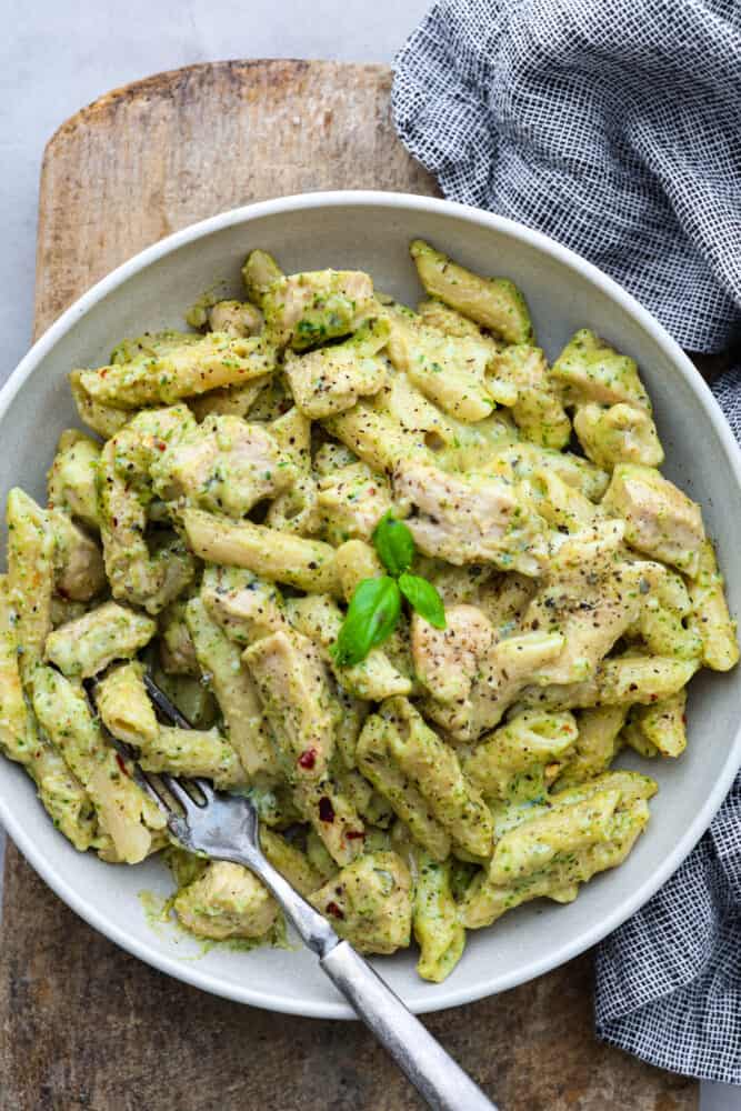 Chicken pesto pasta in a white bowl.