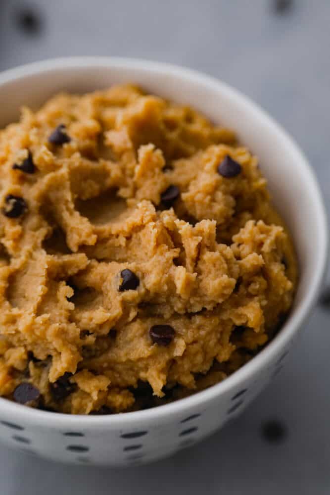 Close-up of chocolate chip cookie dough in white bowl.