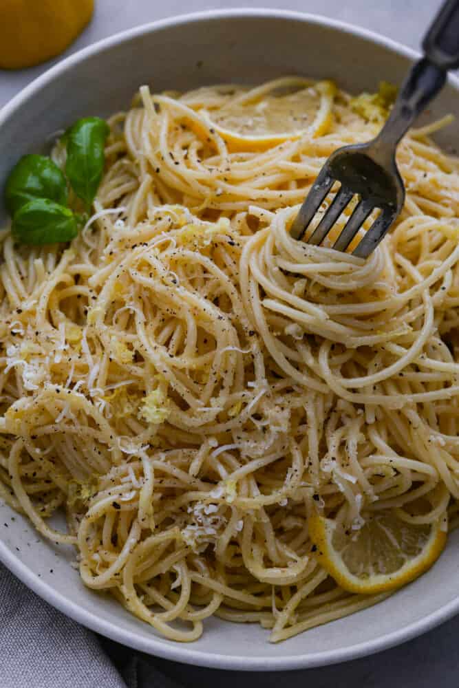 A fork scooping up pasta al limone.