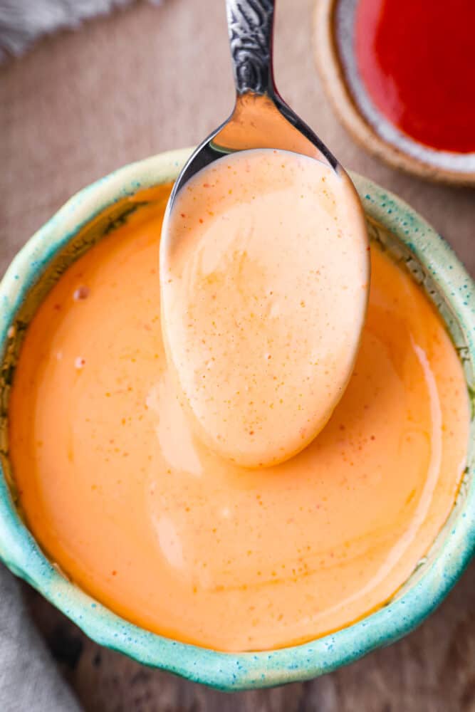 Closeup of sriracha mayo in a green bowl.