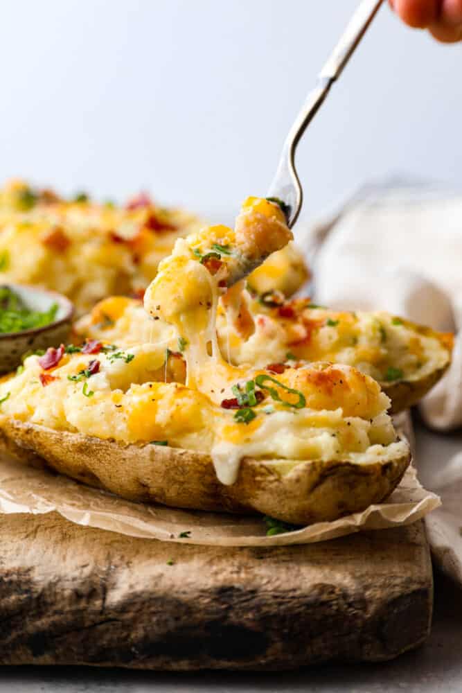 Taking a bite of a twice baked potato with a fork.