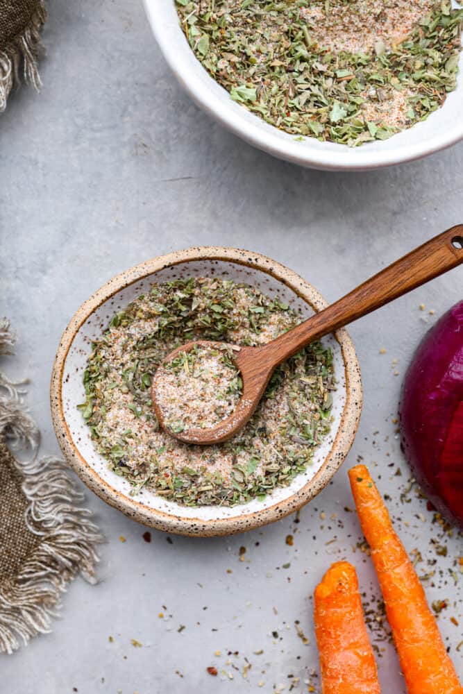 Vegetable seasoning in a bowl with a wooden spoon.