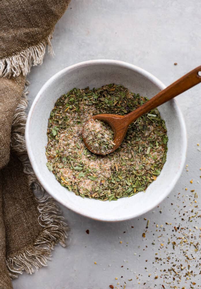 Vegetable seasoning in a bowl with a wooden spoon.