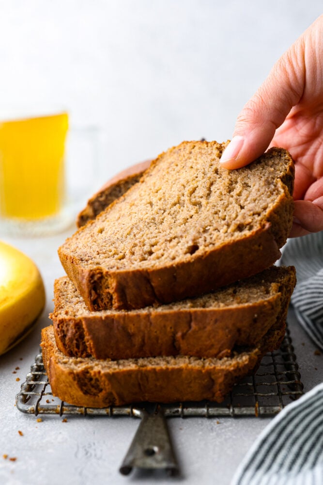 Have you ever tried adding some bubbly goodness to your favorite fruit bread? Well, if you haven't, you're missing out on an amazing treat! This banana beer bread is moist, slightly sweet, with a subtle beer taste that adds a fun twist to the classic banana bread recipe, and the best part? It's super easy to make! 3 slices stacked on top of each other.