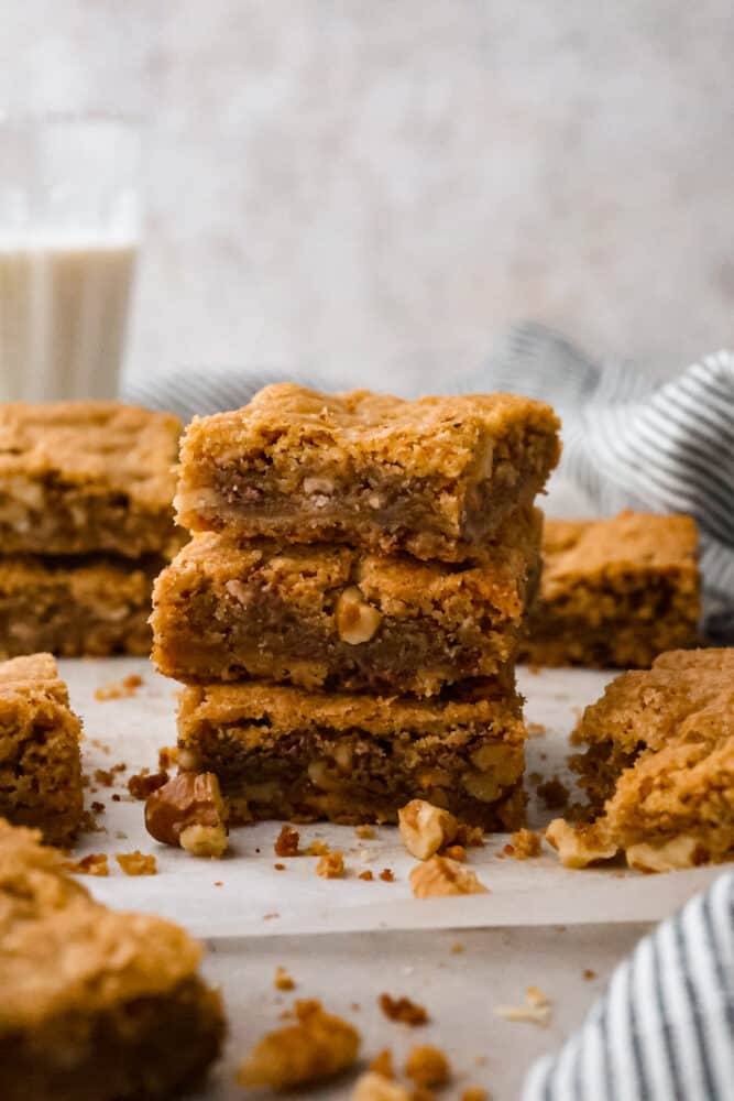 Blondies z brązowego masła ułożone jeden na drugim na talerzu.