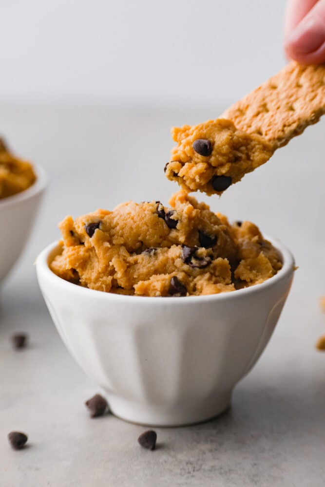 Dipping a cracker in chickpea cookie dough.