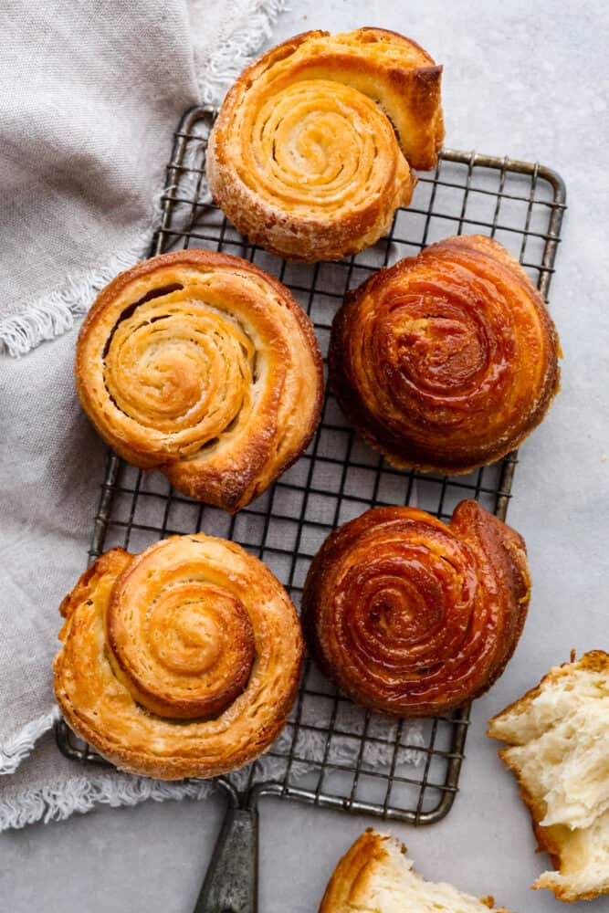 Kouign amman on a wire rack with a grey hand towel.