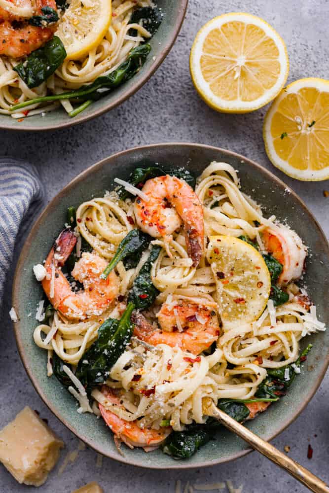 Lemon garlic parmesan shrimp paste in a bowl with fresh lemon cut in half next to it.