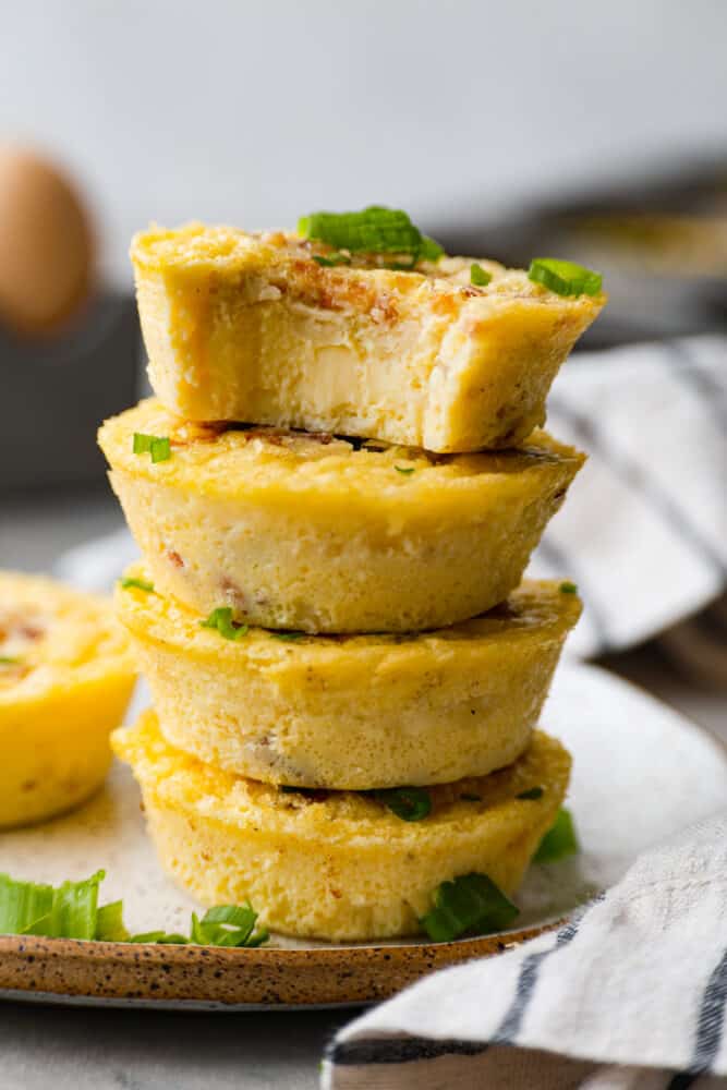 Egg bites stacked on top of each other with a bite taken out of the top one.