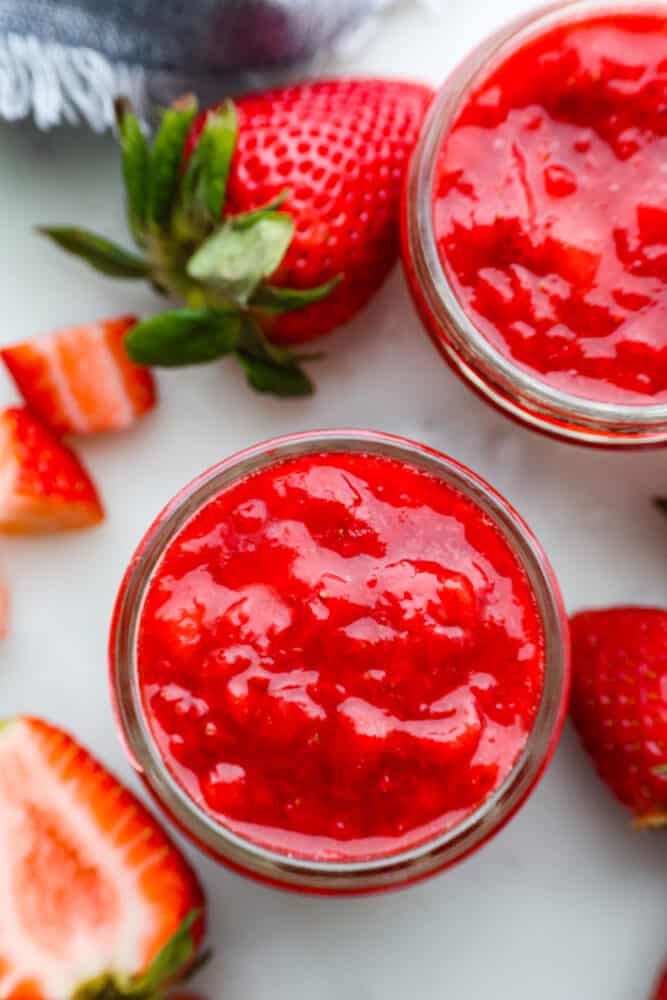 An overhead view of strawberry sauce in a jar.