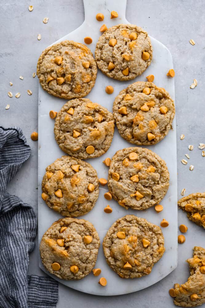 Oatmeal butterscotch cookies on a white serving board.