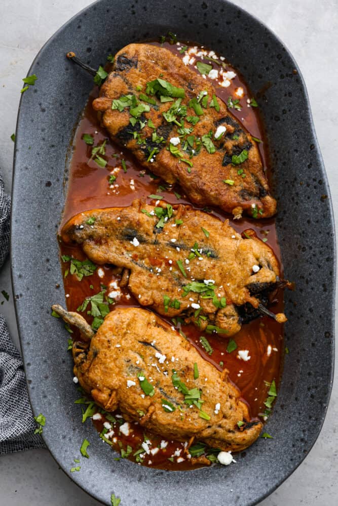 3 chile relleno in a gray serving dish.