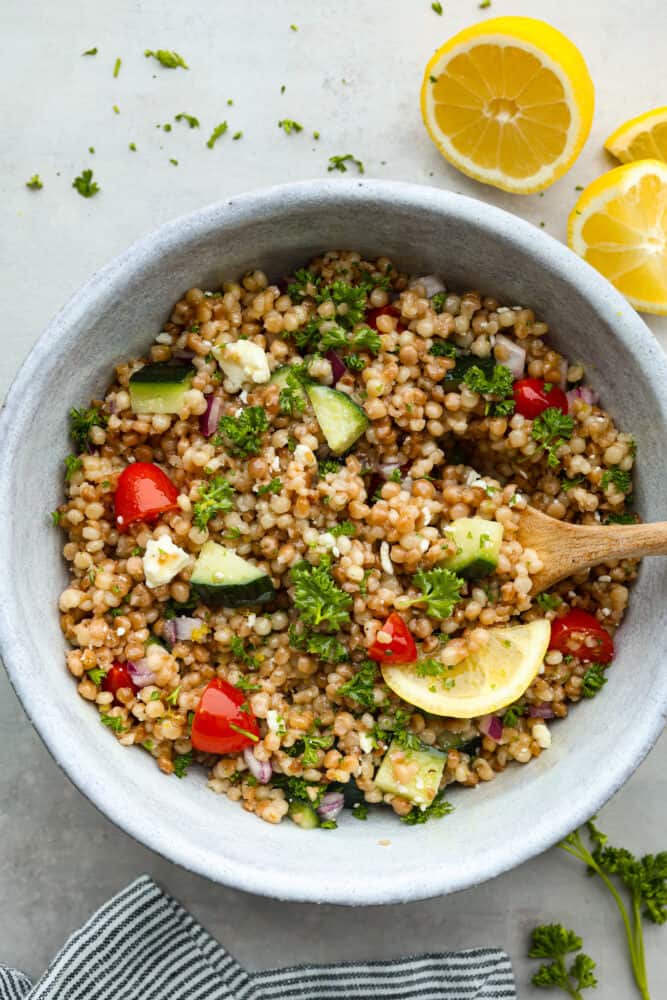 Hero image of couscous salad in a stoneware bowl.