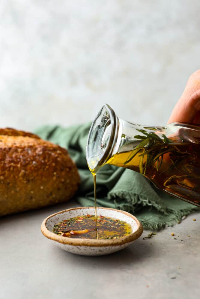 Pouring garlic infused olive oil into a small dish.