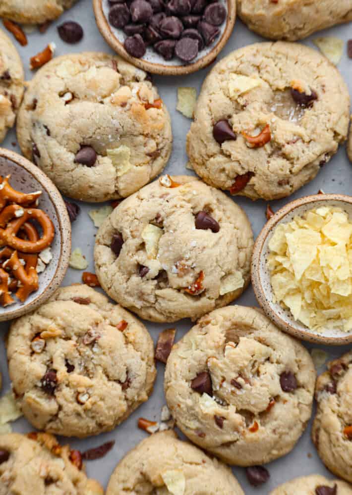 Kitchen sink cookies with extra ingredients surrounding them.