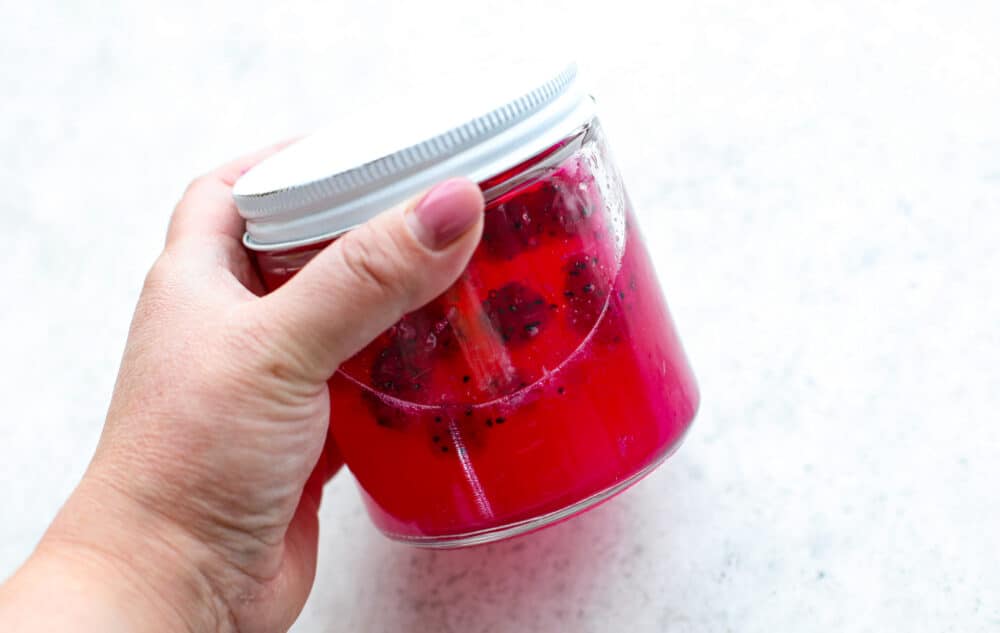 Shaking up the drink ingredients in a sealed jar.