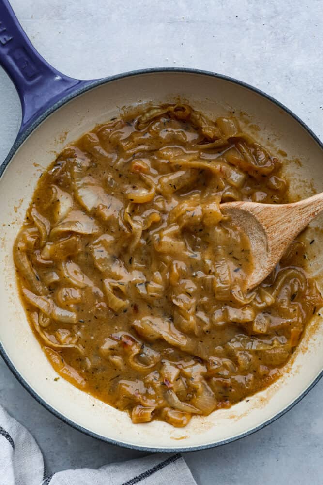 Hero image of onion gravy in a blue and white skillet.