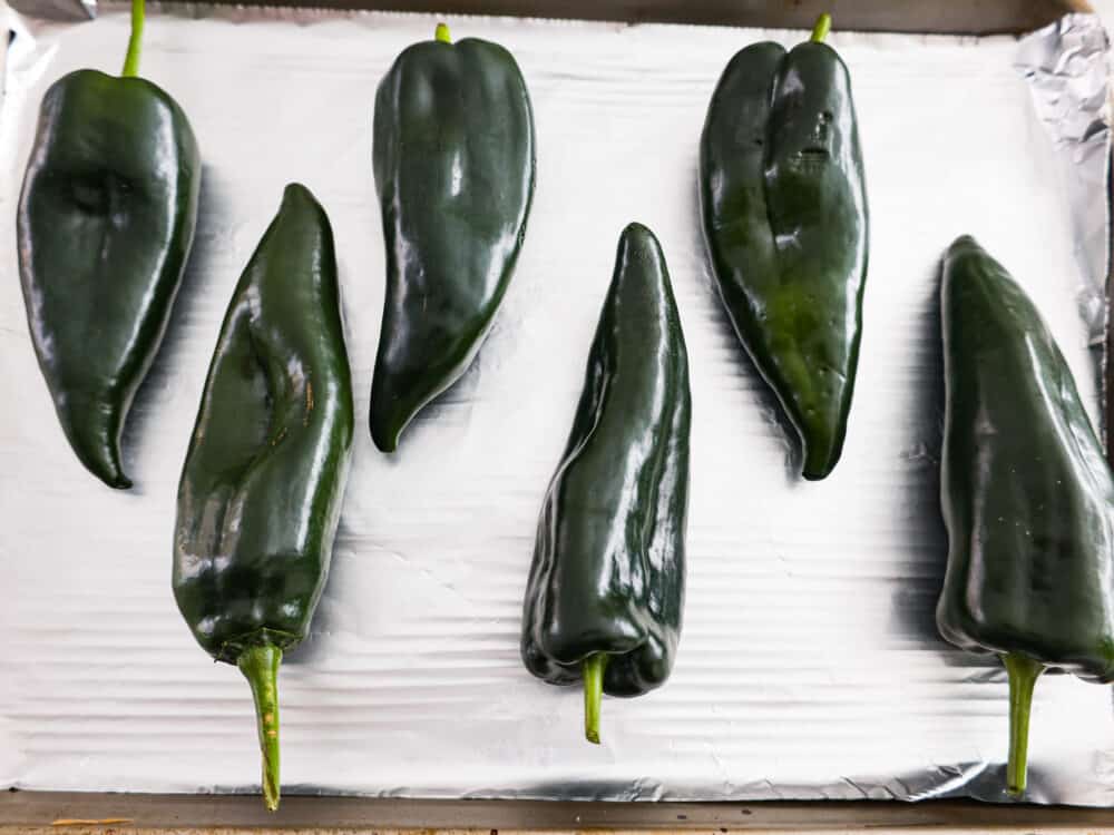 Lining up peppers on a baking sheet.