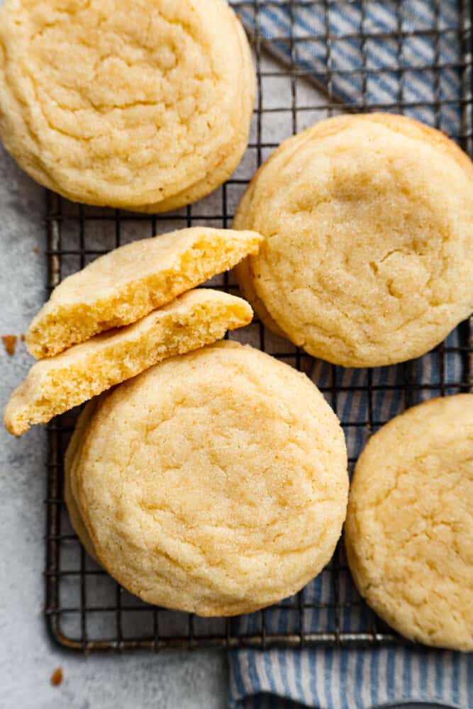 Close up view of stacked sugar cookies on a cooling rack. Cookies are broken in half and stacked next to each other.