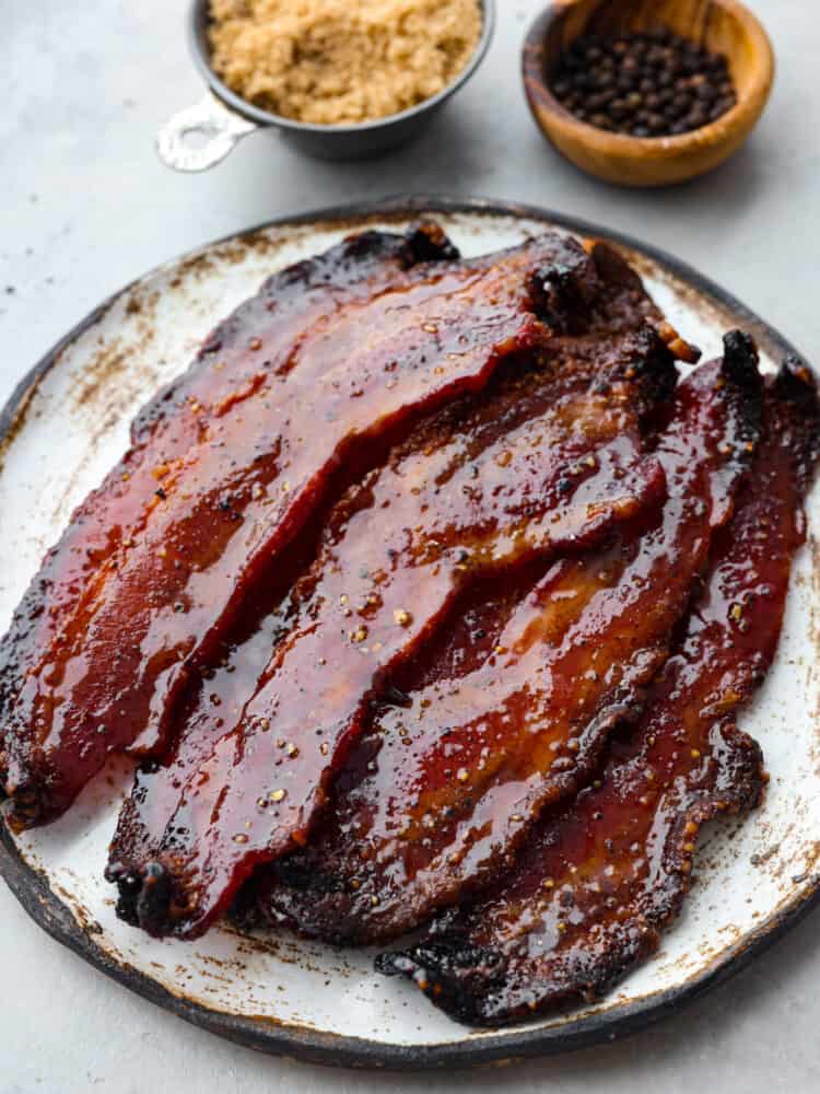 Top down view of candied bacon served on a stoneware plate.