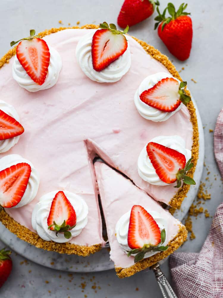 Overhead view of no-bake strawberry cheesecake with a slice being pulled out.