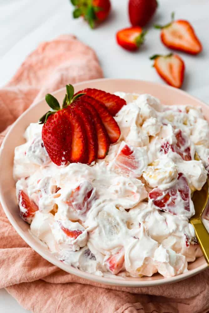 Hero image of strawberry cheesecake salad in a peach-colored bowl.