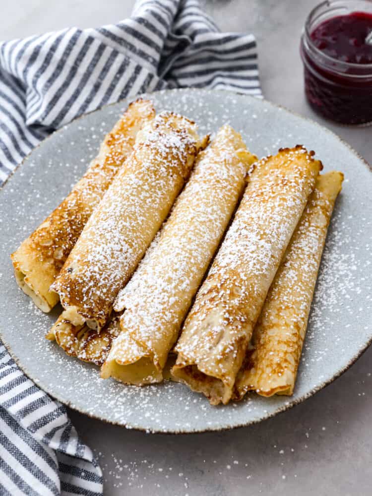 Multiple Swedish pancakes dusted with powdered sugar.