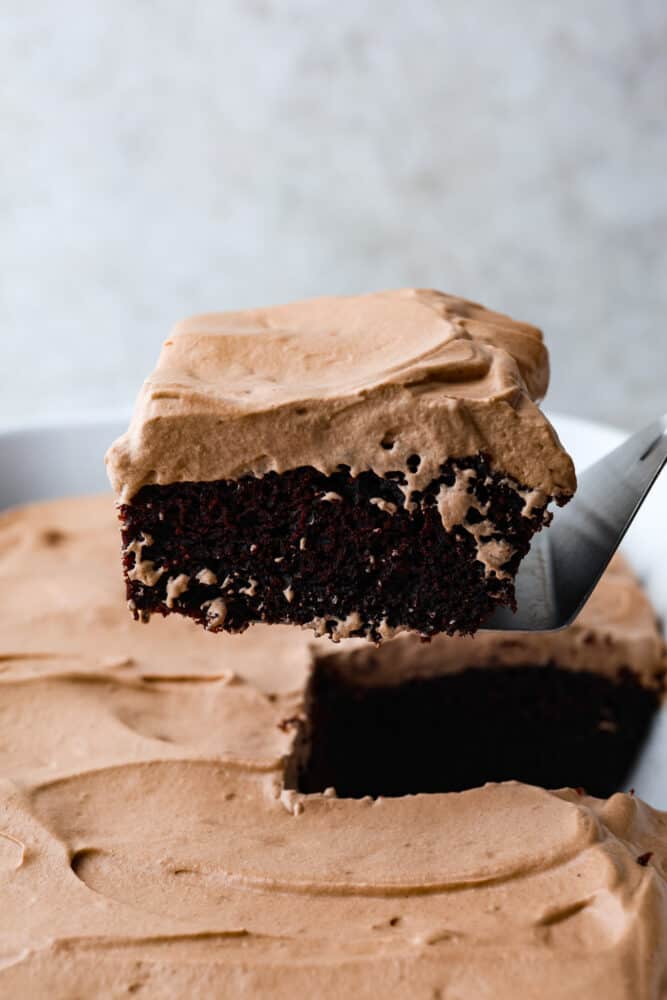 A slice of wacky cake being removed from the pan with a cake server. 